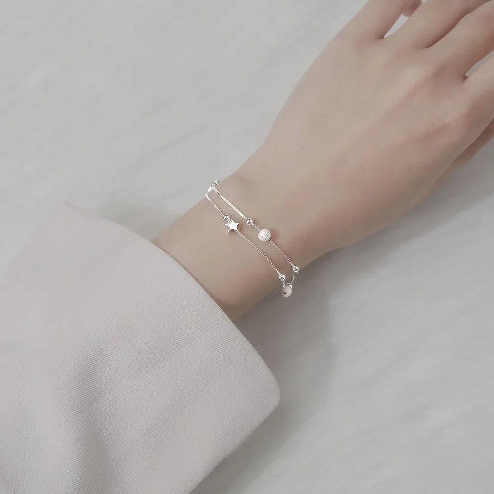 Pulsera de plata con estrellas y múltiples accesorios