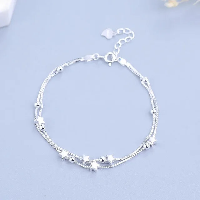 Pulsera de plata con estrellas y múltiples accesorios